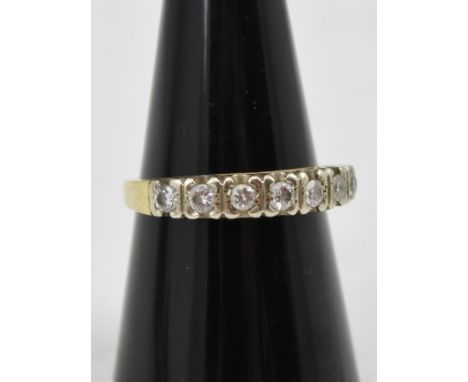 A SEVEN STONE DIAMOND RING set upon an 18ct gold band, size O and half 