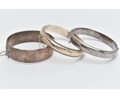 THREE SILVER BANGLES, to include a wide hinged bangle, foliage pattern, push piece clasp, with additional safety chain, hallm