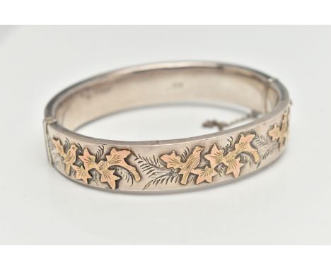 A MID 20TH CENTURY SILVER HINGED BANGLE, yellow metal ivy leaf detail to the one side, push button clasp with additional safe