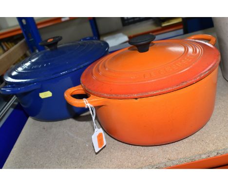 TWO LE CREUSET CASSEROLE DISHES, comprising a Volcanic orange 22cm dish and a deep blue 24cm example, both with lids (2) (Con