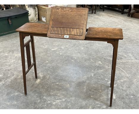 An oak reading table with integral ratchet book stand. 37" wide