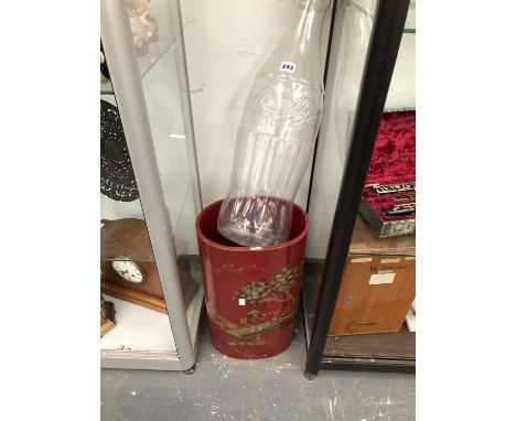 A red ground chinoiserie stick stand together with a shop accessory Coca Cola bottle