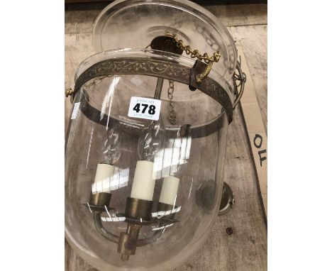 A three bulb ceiling light within a glass lantern with a shade above