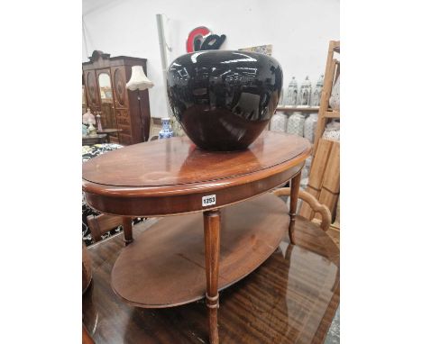 An oval mahogany coffee table a large planter and an occasional table