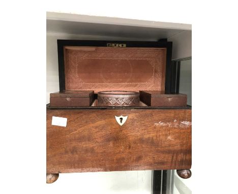 A mahogany sarcophagus tea caddy containing two cannisters and a mixing bowl