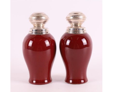 A pair of baluster-shaped porcelain sang de boeuf tea caddy with second grade 835/1000 silver mounts and lid of a later date,