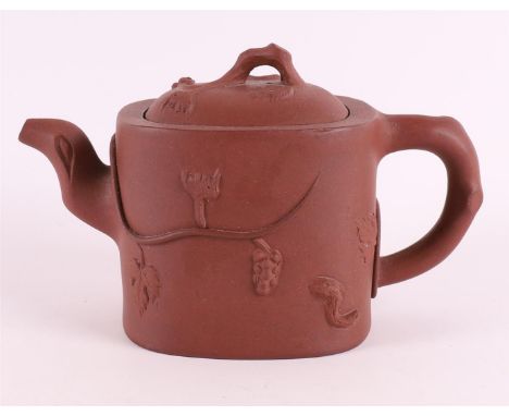 A Yixing tree trunk-shaped teapot, China 19th/20th century. Relief of grape vines, marked with character mark on the inside o