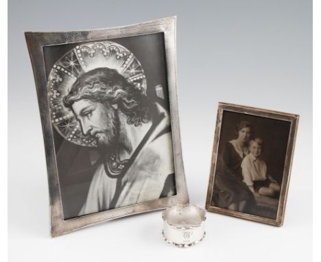 A white metal photograph frame, with engine turned decoration, together with a hallmarked silver photograph frame and a hallm