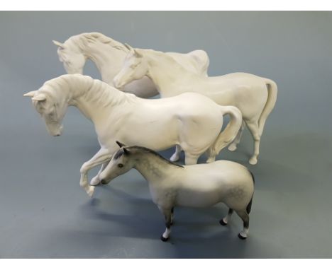 Two Royal Doulton white ceramic horses, a white Beswick horse, and a grey Beswick horse.