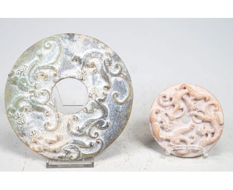 2 Bi discsjadeite, nephrite; one side carved with fully sculpted tigers, reverse with graphic incised or carved pattern, appr