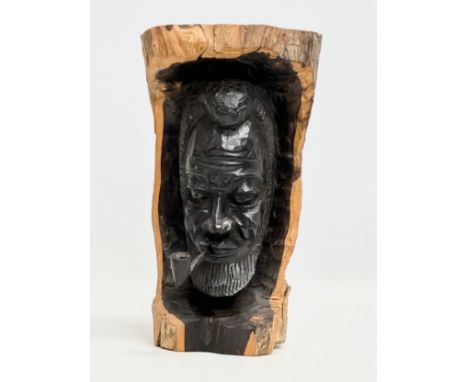An African carved tree trunk sculpture with removable pipe. 27cm
