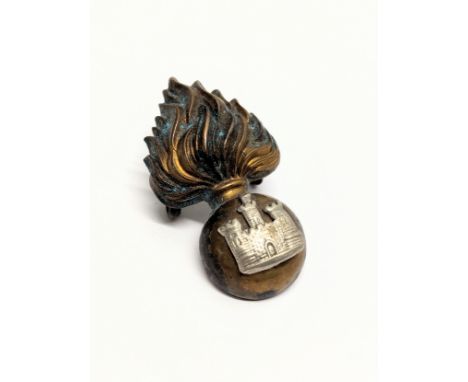 A vintage brass Royal Inniskilling Fusiliers cap badge.
