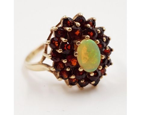 A 9ct gold, fire opal and garnet stone cluster ladies ring. 3.4g total weight. Size P. 