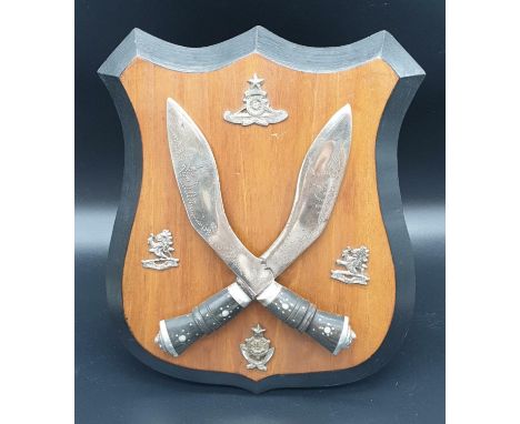 A Vintage Gurkha Regiment Wooden Shield, fitted with cross Kukri's and 4 cap badges. 