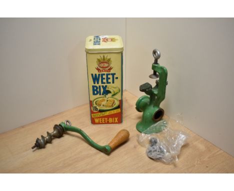 A vintage green enamelled meat mincer with hand crank and a Bokomo Weet-Bix lithographed advertising tin