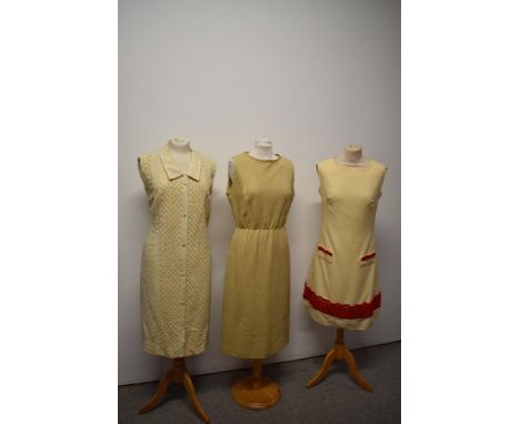 Three vintage 1960s dresses, one mid length metallic dress, a red and cream wool mini dress and a beige linen dress.
