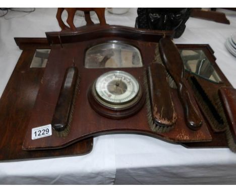 A barometer on a brush rack and one other brush rack