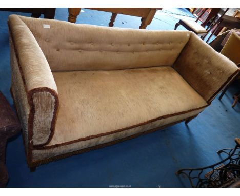 A beige upholstered three seater sofa.