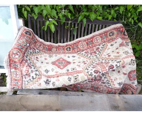 A red/cream carpet, as found, 7' x 4'.