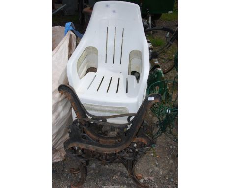 Four plastic stacking chairs and a pair of cast iron bench ends.
