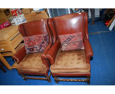 A pair of vintage faux leather fireside armchairs having upholstered velvet seats, plus two carpet cushions.