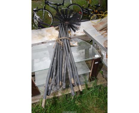 A quantity of drain rods and chimney sweep head.