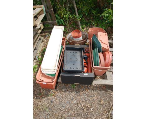 A large quantity of plastic flower pots, saucers and oblong planters.