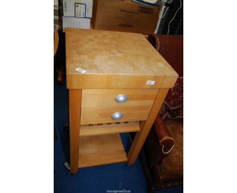 A Pine butchers block with two drawers and shelf, on castors, 20" x 20" x 36 1/2" high.