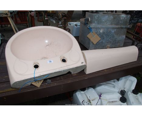 A cream coloured hand basin and pedestal.
