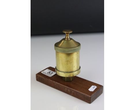 A brass vintage Steam Car oil valve mounted on a wooden plinth. 