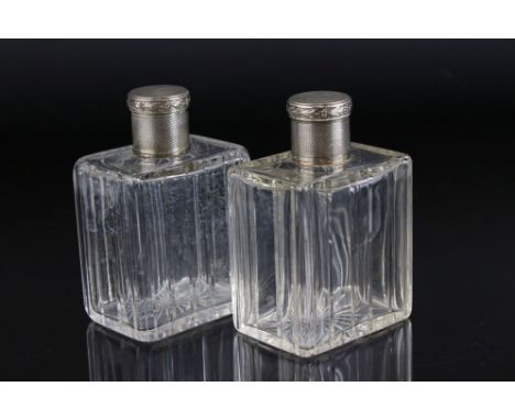 A pair of French scent bottles with engine turned decorated lids, one to include glass stopper, continental silver marks to t