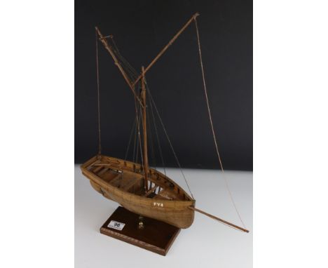 A kit built wooden model of a ship with exposed side, mounted to stand. 
