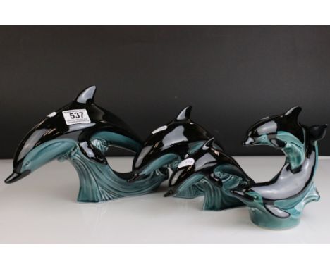 Four Poole Pottery Dolphin Figures. 
