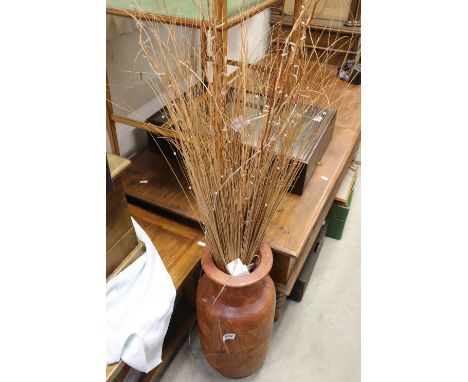 A contemporary ceramic brown vase with grasses. 