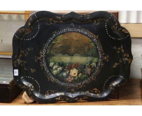A large 19th century papier Mache scalloped edged tray with floral and leaf decoration and central panel with lake and folly 