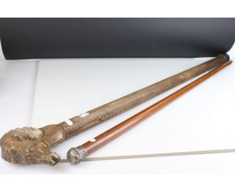 A black forest style walking stick with carved Rams head handle together with a silver topped Malacca walking cane. 