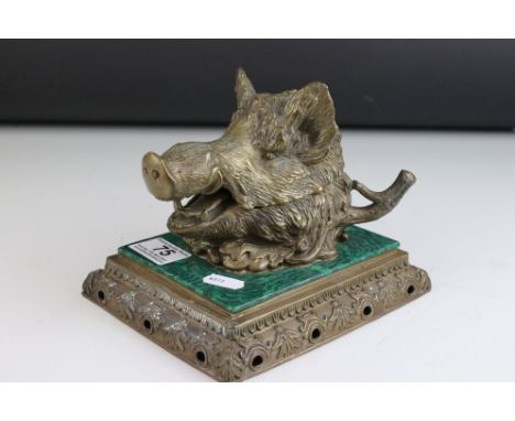 A mid 19th century inkwell in the form of a Wild Boars head mounted on a ceramic malachite style base, blue printed mark to u
