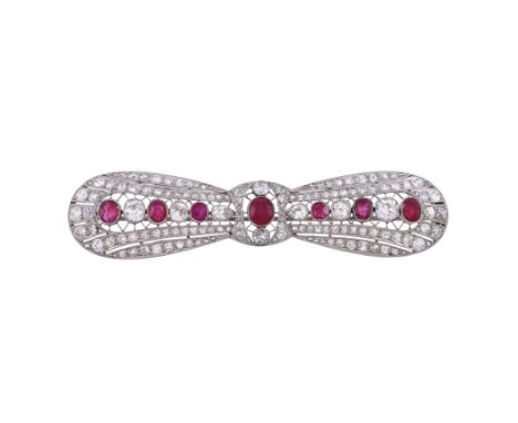 An early 20th century ruby and diamond bow brooch, circa 1920, the pierced lobed bow set with seven graduated cushion cut rub