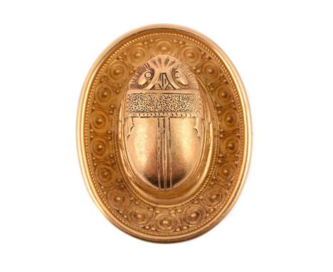 A mid 19th century historical revival gold brooch, circa 1860, the central raised scarab within a bowl shaped oval beaded and