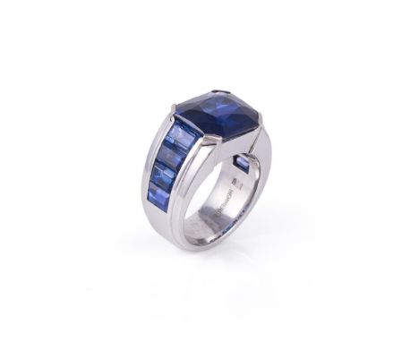 A sapphire dress ring by Hemmerle, the mixed cut sapphire estimated to weigh 10.18 carats, to step cut channel set sapphire s