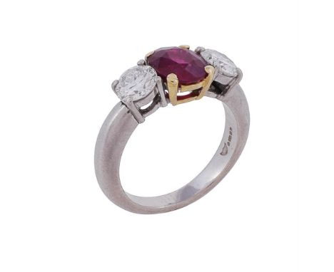 A three stone ruby and diamond ring, the central oval cut ruby estimated to weigh 1.70 carats, flanked by two brilliant cut d