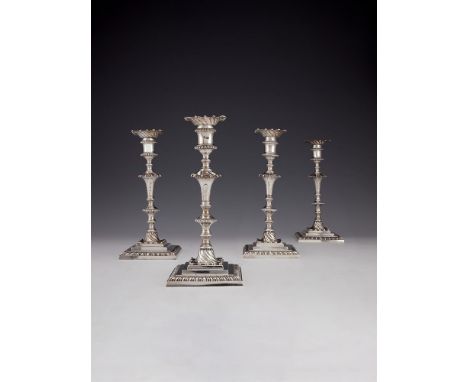 A set of four early George III cast silver square candlesticks by Ebenezer Coker, London 1764, with wrythen fluted sconces, t
