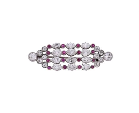 A ruby and diamond lozenge shaped brooch, the rows of alternating marquise and pear cut diamonds interspaced by circular cut 