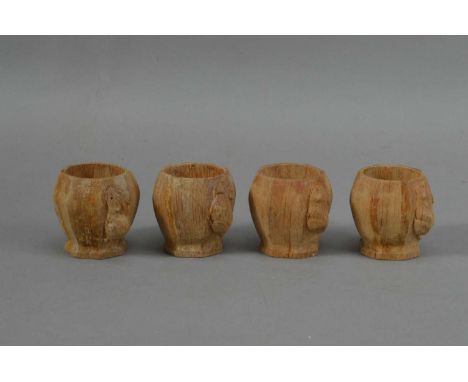 Workshop of Robert 'Mouseman' Thompson, four carved oak egg cups, each with the signature carved mouse, all approx. 5cm H x 5