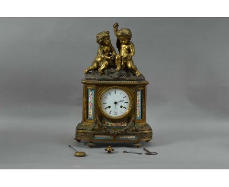A French porcelain and brass mantle clock, two children above the enamel dial with Roman Numerals, painted porcelain panels o