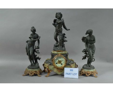 A clock garniture, the clock with a cast metal cherub, the dial with Arabic Numerals, the two sculptures of women, all on mar