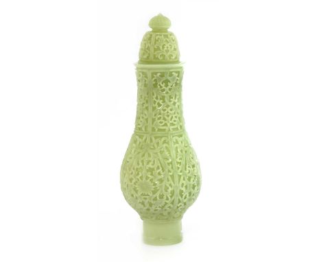 A Chinese jade vase and cover, of baluster form, profusely carved with scrolling lotus in shaped panels, the domed cover simi