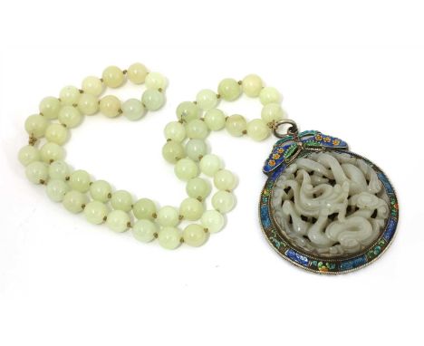 A Chinese jade and cloisonné pendant, of a butterfly above a circular dish with scrolling flowers, inset with a jade carving 