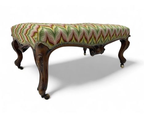 Victorian walnut framed footstool, upholstered in flame stitch fabric, serpentine seat rail with central carved motif, raised