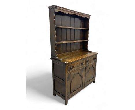 Jacobean design oak dresser, raised back with three fixed shelves above a rectangular top with scalloped detailing, the base 